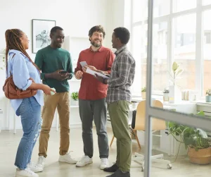 a group of diverse people talking to each other while using mobile phones